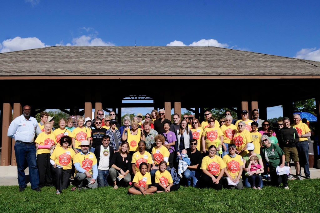 A large group of supporters in matching yellow No Rt. 53 Tax Hike shirts posing in front of a park pavilion